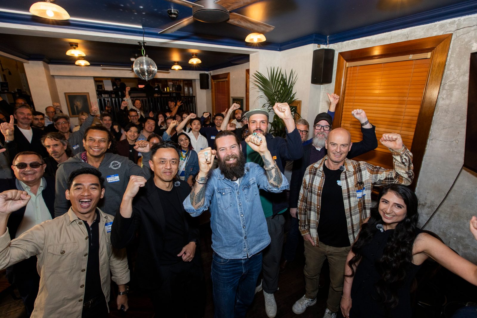 A Creator Co-labs crowd cheering with fists raised