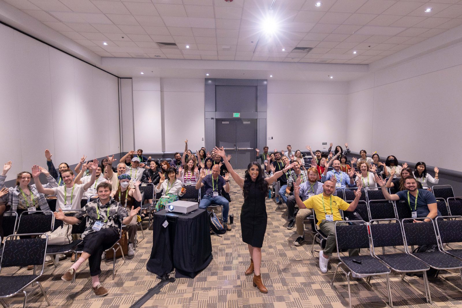 Annemarie with a full room of workshop participants waving at the camera