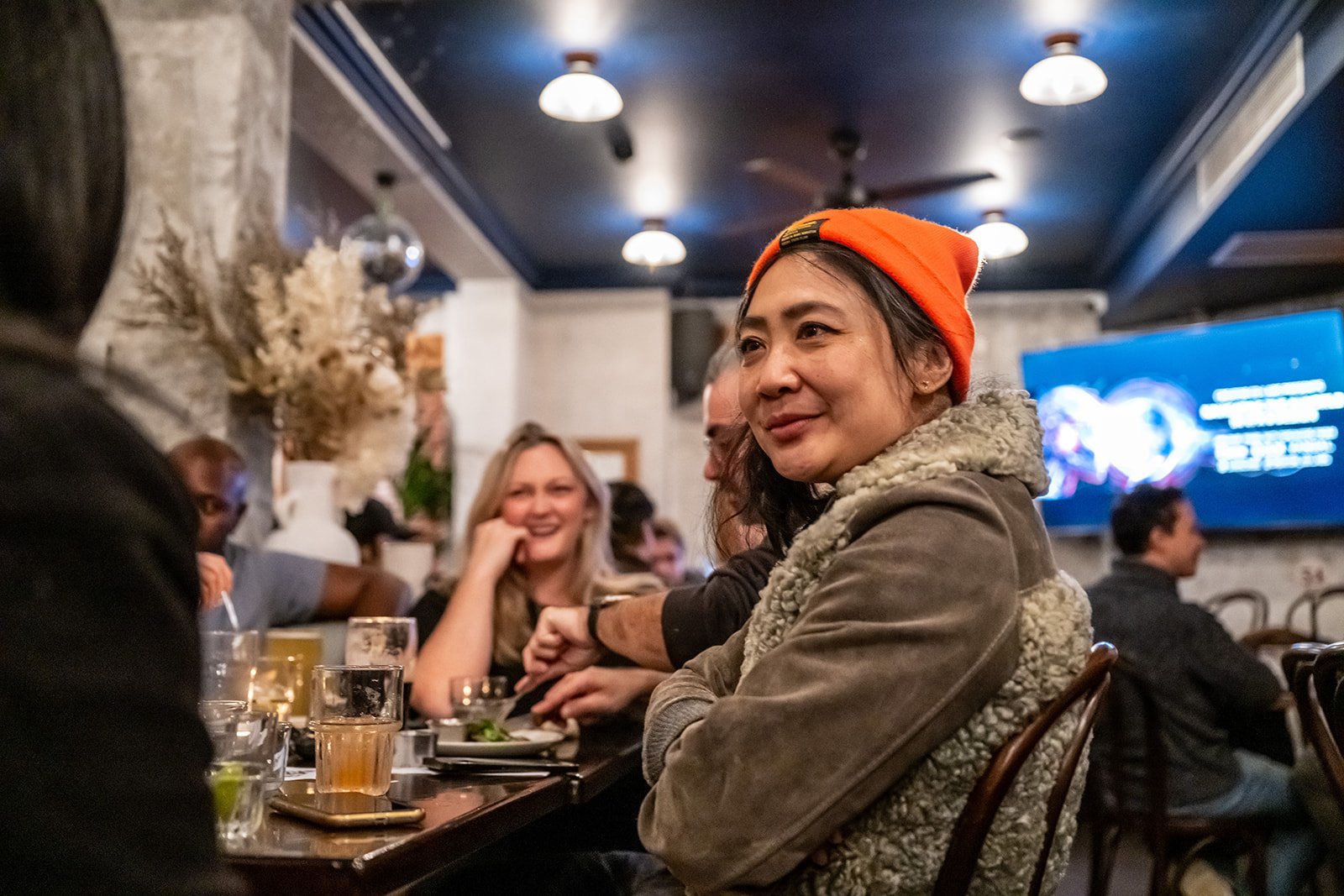 A guest in an orange beanie listening